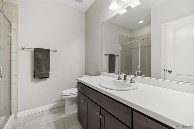 full bath featuring a shower stall, toilet, baseboards, vanity, and tile patterned floors