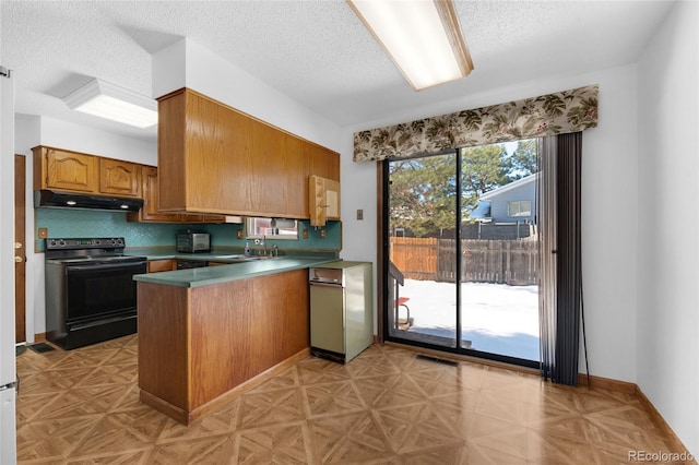 kitchen featuring black electric range oven, sink, backsplash, kitchen peninsula, and a textured ceiling