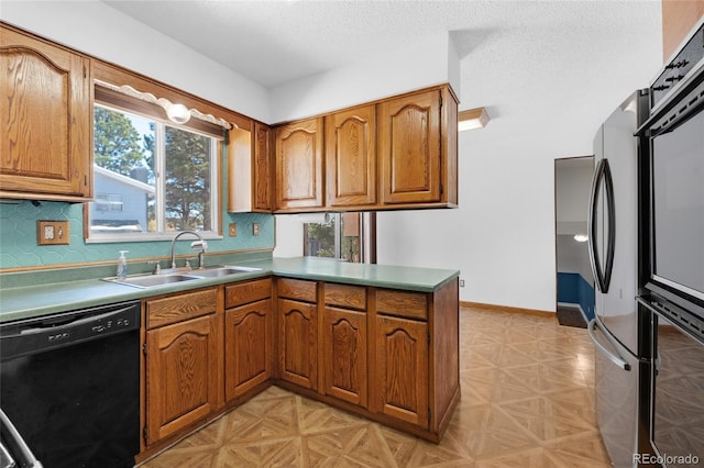 kitchen featuring sink, tasteful backsplash, a textured ceiling, kitchen peninsula, and black appliances