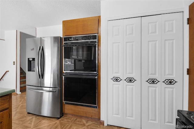 kitchen featuring black double oven, stainless steel fridge with ice dispenser, a textured ceiling, and light parquet floors