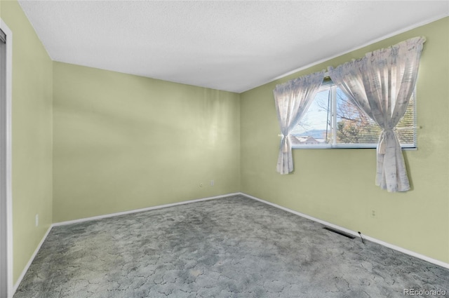 unfurnished room featuring a textured ceiling and carpet flooring