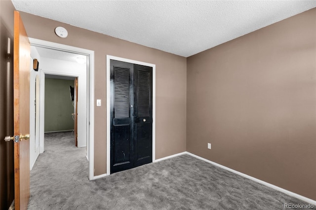 unfurnished bedroom featuring a closet, carpet floors, and a textured ceiling