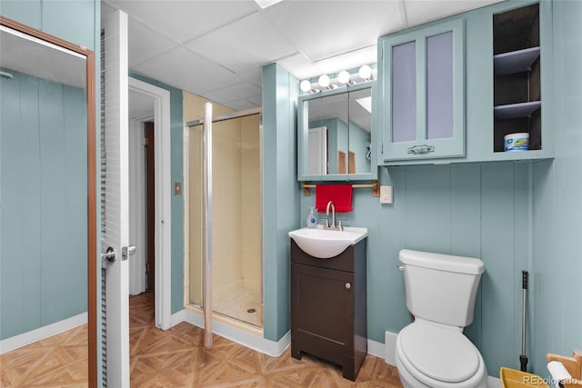 bathroom featuring parquet flooring, vanity, toilet, and a shower with shower door