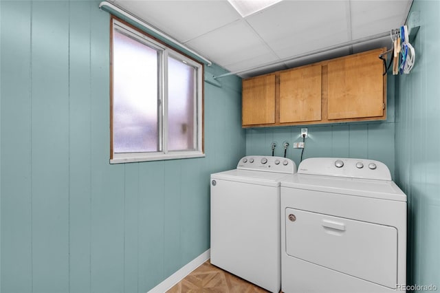 washroom with washer and clothes dryer, cabinets, and light parquet floors