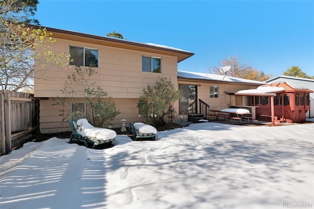 view of snow covered rear of property