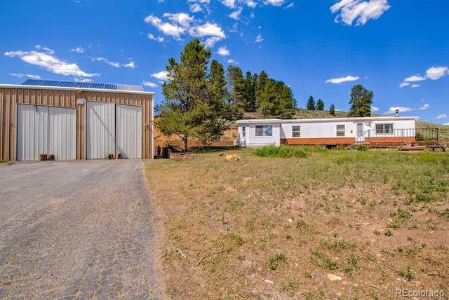 exterior space featuring a garage and an outbuilding