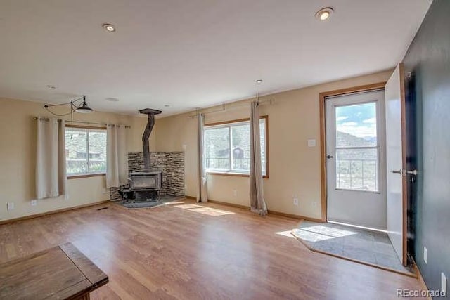 unfurnished living room featuring light hardwood / wood-style flooring and a wood stove