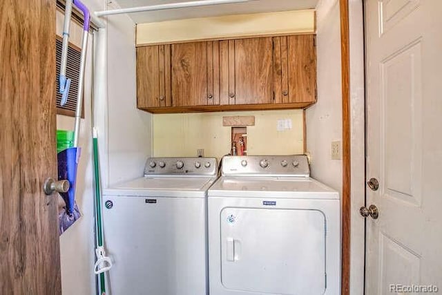 laundry room featuring washer and dryer and cabinets