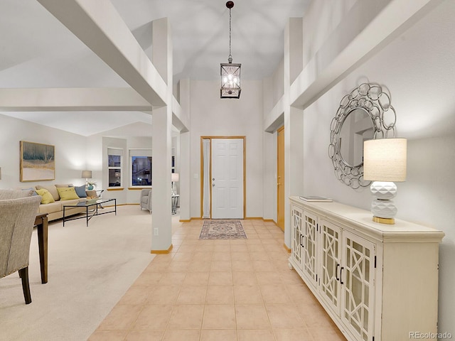 entryway with light carpet, high vaulted ceiling, and a notable chandelier