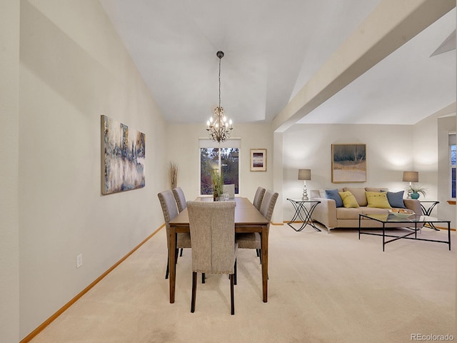 dining space with a chandelier, light colored carpet, and vaulted ceiling