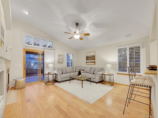 living room featuring high vaulted ceiling, light hardwood / wood-style flooring, and ceiling fan