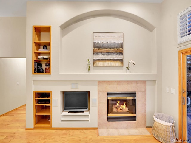 room details featuring a fireplace, hardwood / wood-style floors, and built in features