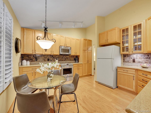 kitchen featuring appliances with stainless steel finishes, light brown cabinets, tasteful backsplash, and hanging light fixtures