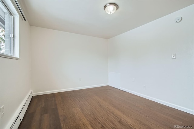 unfurnished room featuring dark hardwood / wood-style floors and a baseboard heating unit