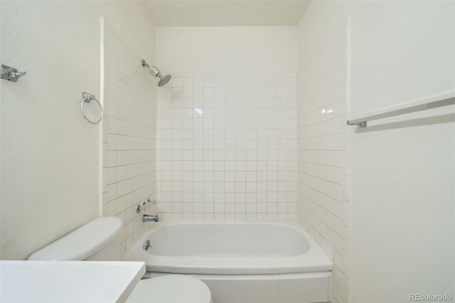 bathroom with tiled shower / bath and toilet