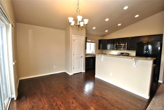 kitchen with light stone counters, black appliances, lofted ceiling, pendant lighting, and a kitchen bar