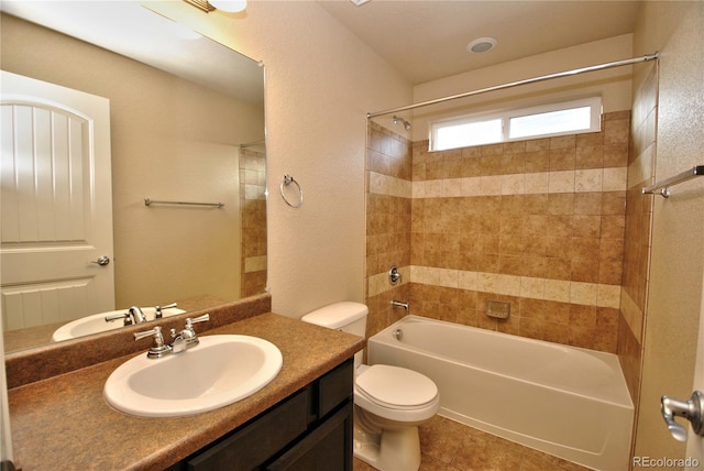 full bathroom with tile patterned flooring, toilet, vanity, and tiled shower / bath