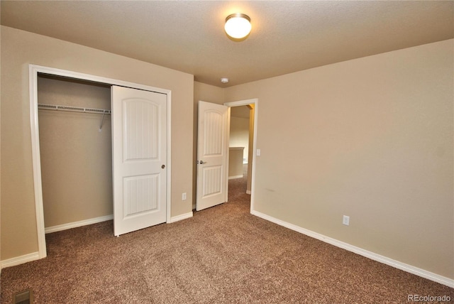 unfurnished bedroom featuring carpet, a textured ceiling, and a closet