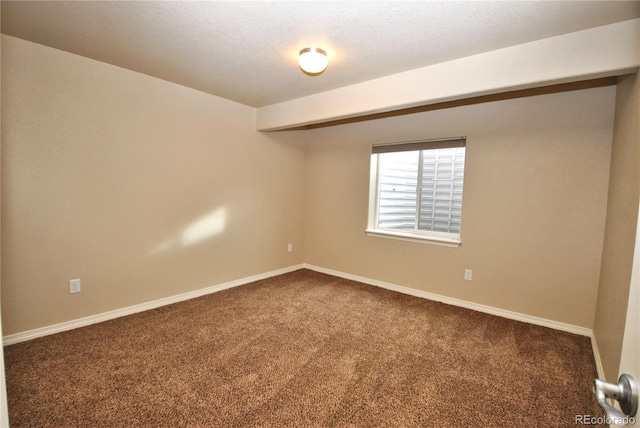 spare room with dark carpet and a textured ceiling