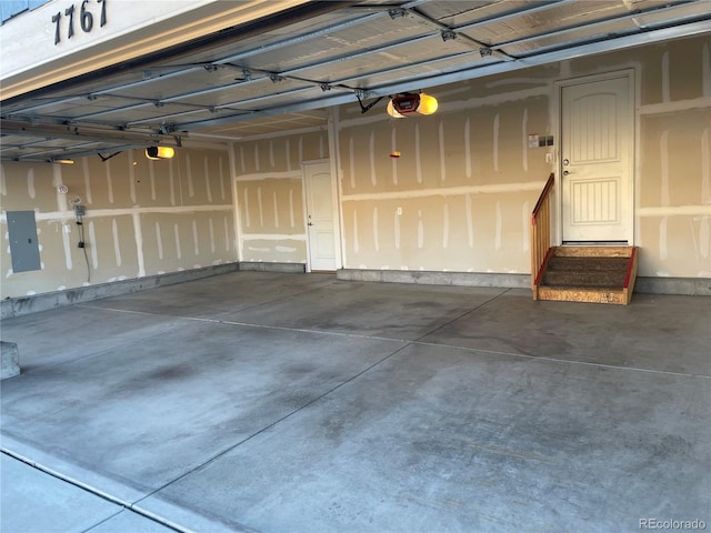 garage featuring electric panel and a garage door opener