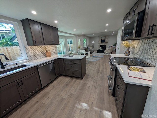 8129 S Yukon St S, Littleton, CO 80128 - kitchen with stainless steel appliances, recessed lighting, a peninsula, light wood-style flooring, and decorative backsplash