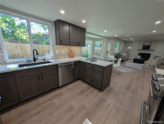 8129 S Yukon St S, Littleton, CO 80128 - kitchen with stainless steel appliances, a peninsula, light wood-type flooring, recessed lighting, and decorative backsplash
