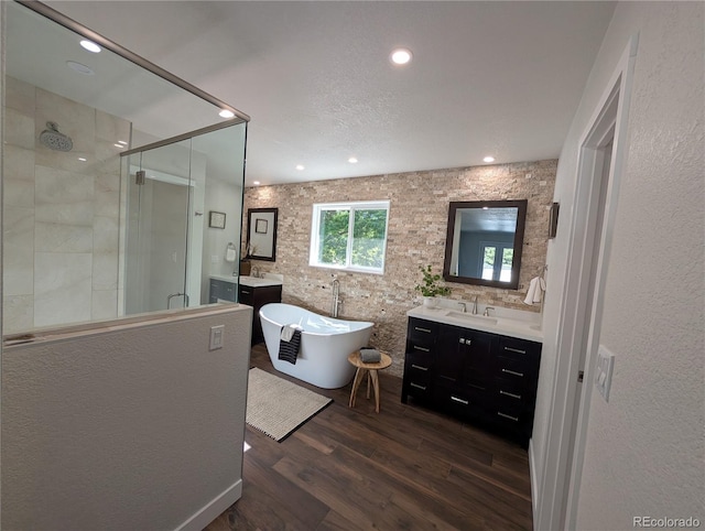 8129 S Yukon St S, Littleton, CO 80128 - full bathroom featuring a shower stall, vanity, wood finished floors, a soaking tub, and recessed lighting