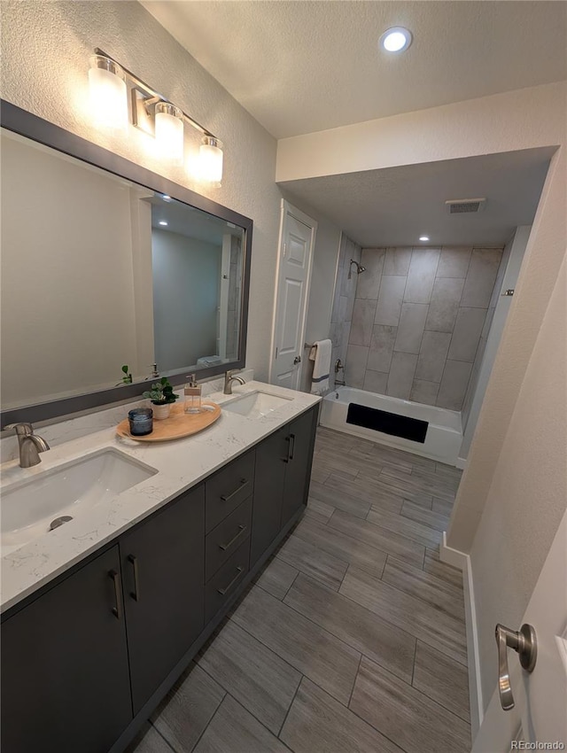 8129 S Yukon St S, Littleton, CO 80128 - bathroom with double vanity, shower / bath combination, a textured ceiling, a textured wall, and recessed lighting