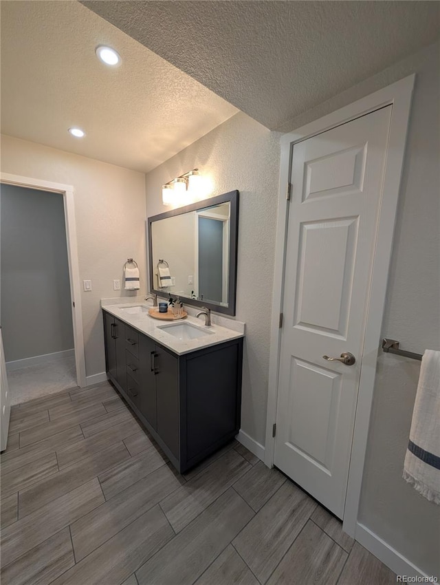 8129 S Yukon St S, Littleton, CO 80128 - full bathroom with a textured ceiling, double vanity, wood finish floors, and recessed lighting