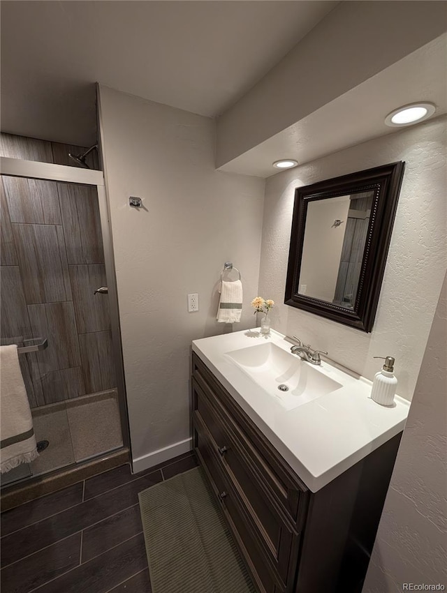 8129 S Yukon St S, Littleton, CO 80128 - full bathroom featuring vanity, a tile shower, and a textured wall