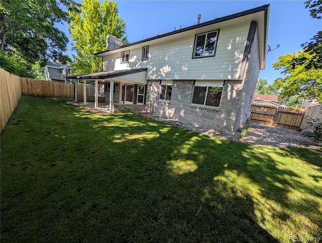 8129 S Yukon St S, Littleton, CO 80128 - rear view of property featuring a chimney, brick siding, a fenced backyard, and a patio area