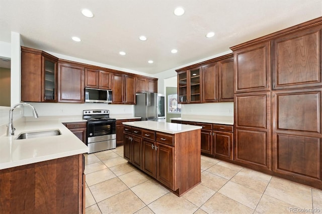 kitchen featuring sink, light tile patterned flooring, stainless steel appliances, and a kitchen island