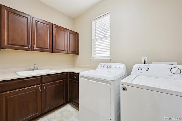 clothes washing area with sink, cabinets, and washing machine and clothes dryer