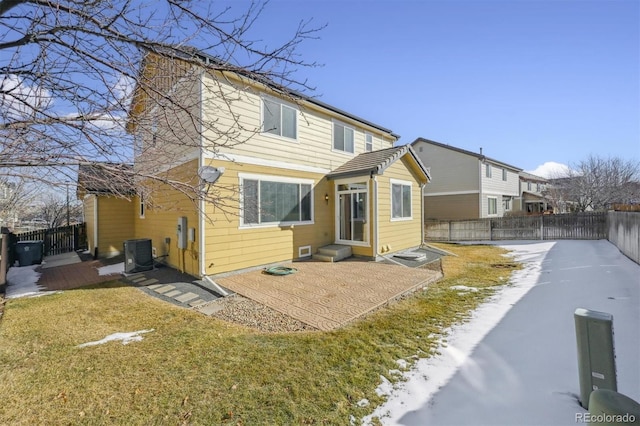 rear view of house with a patio, a yard, and central AC