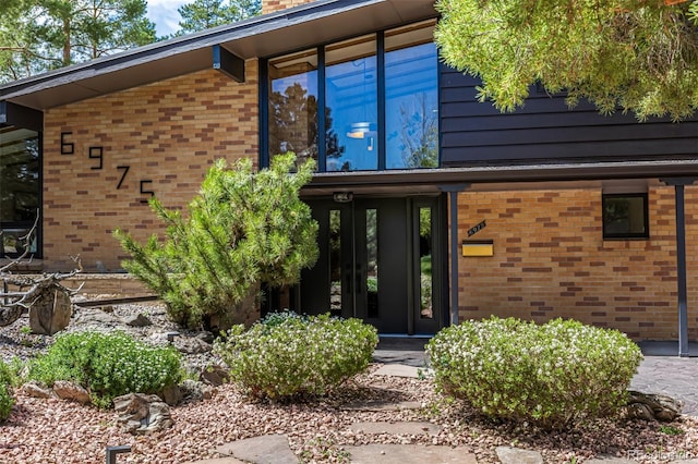 view of exterior entry with brick siding