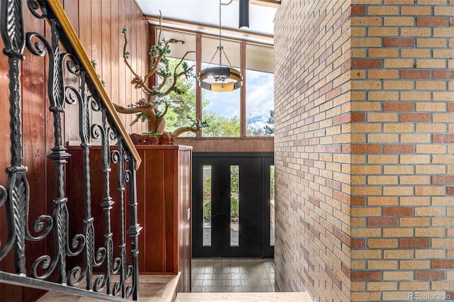 foyer featuring brick wall