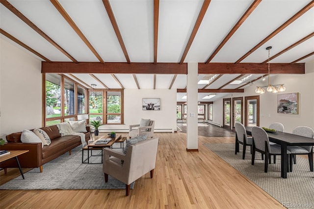 living area featuring vaulted ceiling with beams, a baseboard radiator, light wood-style floors, and a notable chandelier