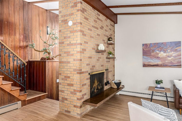 living room featuring baseboard heating, stairway, and wood finished floors