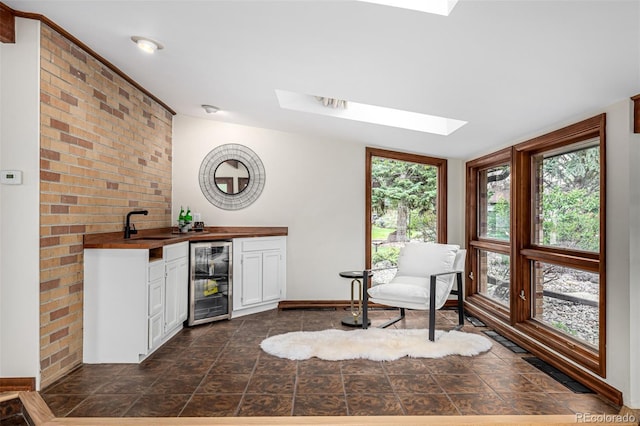 bar featuring plenty of natural light, indoor wet bar, beverage cooler, and visible vents
