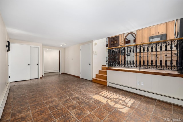 unfurnished room with baseboards, a baseboard radiator, baseboard heating, and stairway