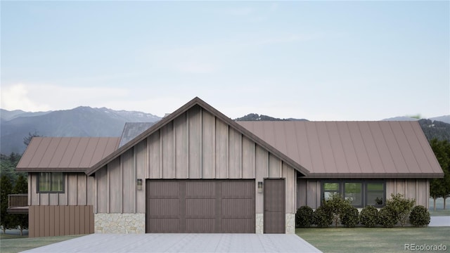 967 W Elk Meadows Dr, Tabernash, CO 80446 - view of front of house with an attached garage, a mountain view, stone siding, and concrete driveway
