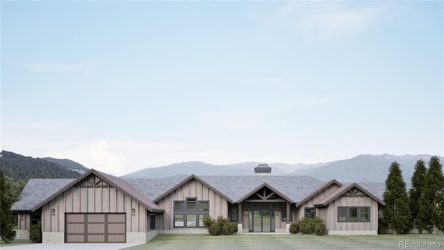 967 W Elk Meadows Dr, Tabernash, CO 80446 - view of front of house featuring a mountain view, board and batten siding, an attached garage, and driveway