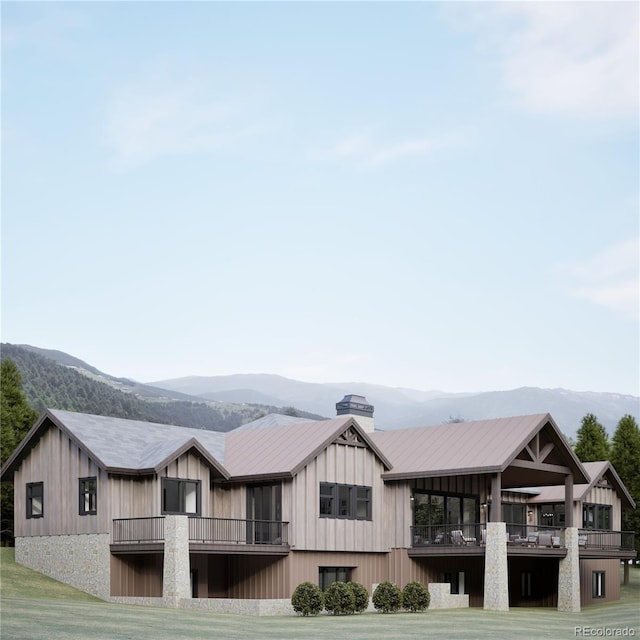 967 W Elk Meadows Dr, Tabernash, CO 80446 - rear view of house with a mountain view, a balcony, a chimney, and a lawn