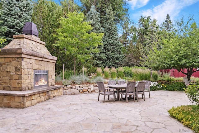 view of patio / terrace with an outdoor stone fireplace and outdoor dining area