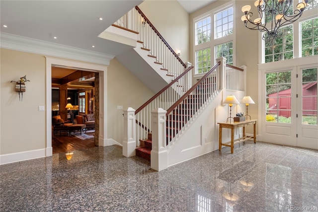 staircase with a high ceiling, granite finish floor, crown molding, baseboards, and a notable chandelier