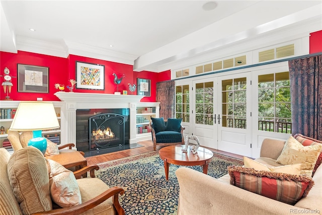 living area featuring recessed lighting, wood finished floors, a lit fireplace, and ornamental molding