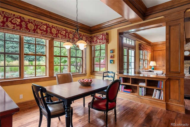 dining area with wood-type flooring and ornamental molding