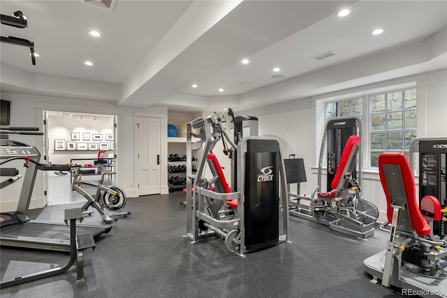 gym featuring recessed lighting, a raised ceiling, and visible vents