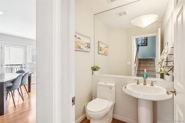 bathroom featuring toilet, wood finished floors, and visible vents