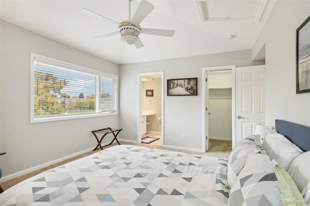 bedroom featuring a spacious closet, a ceiling fan, baseboards, and light carpet